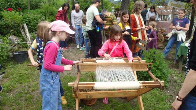 Kinder weben die gewonnene Wolle Kinder weben die gewonnene Wolle